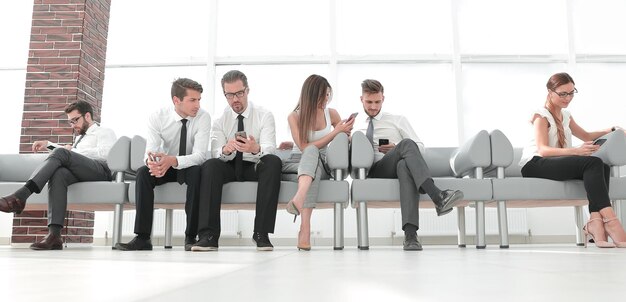 Business team with mobile phones sitting in the lobby of the officephoto with copy space