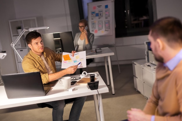 Photo business team with papers working late at office