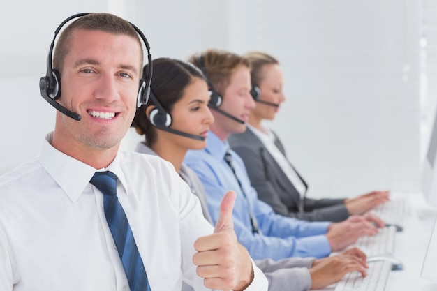 Business team working on computers and wearing headsets