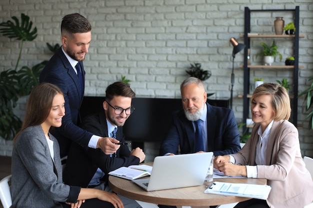 Business team working on laptop to check the results of their work.