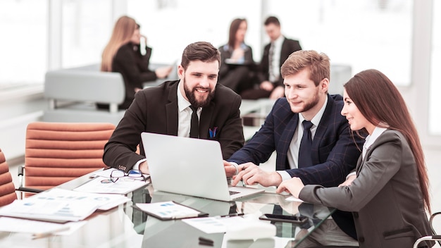 Business team working on laptop with financial records in the modern office