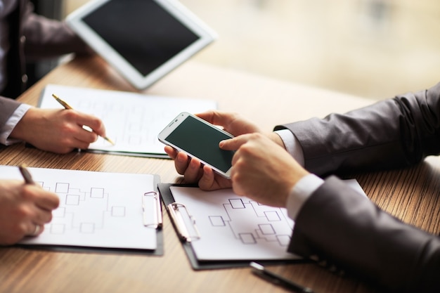 Squadra di affari che lavora su un business di regime utilizzando il tablet e lo smartphone