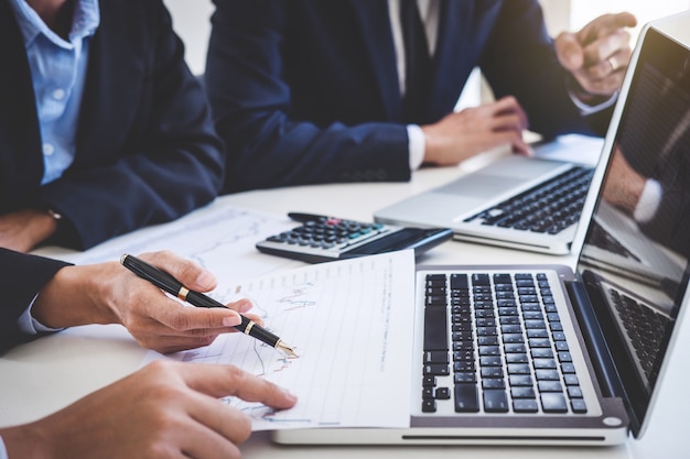 Business team working with computer, laptop, discussing and analysis graph stock market trading