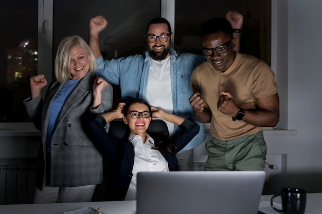 Foto compagni di squadra di lavoro che lavorano fino a tardi in ufficio