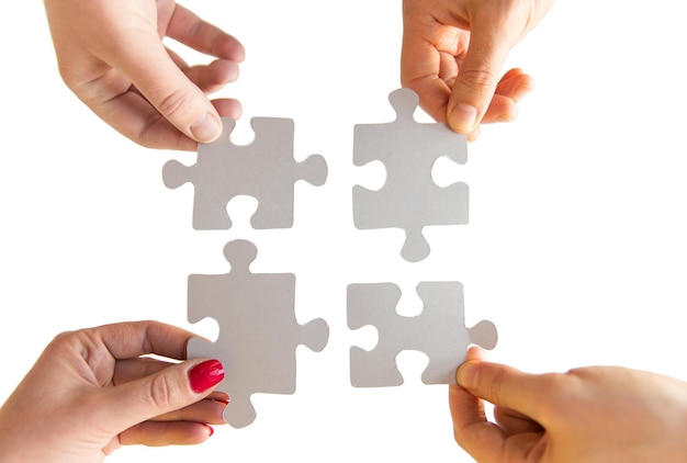 business, teamwork, cooperation, compatibility and connection concept - close up of hands connecting puzzle pieces