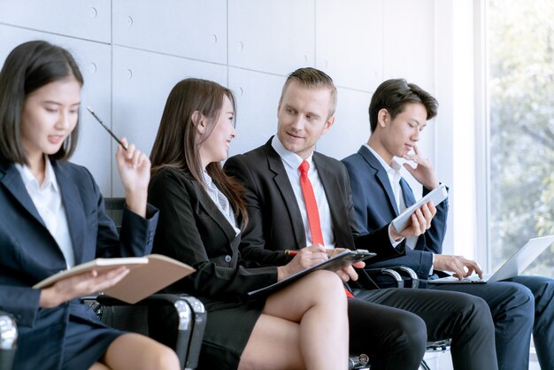 Lavoro di squadra di affari che discute lavoro mentre aspettando il progetto attuale al cliente