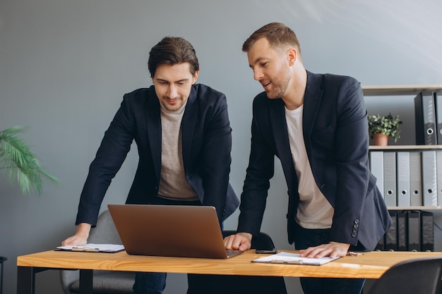 Business teamwork two corporate businessmen working together on laptop