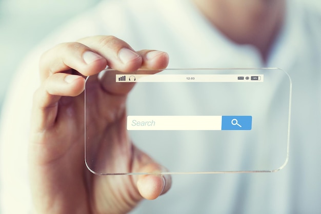 business, technologie en mensen concept - close-up van mannenhand die transparante smartphone vasthoudt en toont met de zoekbalk van de internetbrowser
