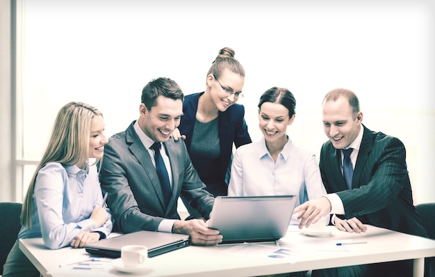 business, technologie en office concept - glimlachend business team met laptop computers, documenten en koffie met discussie op kantoor