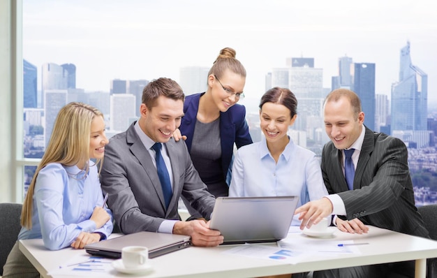 Business, technologie, teamwork en mensen concept - glimlachend business team met laptop computers, documenten en koffie discussie over kantoor achtergrond