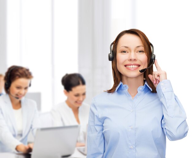 business, technology and call center concept - friendly female helpline operator with headphones at office