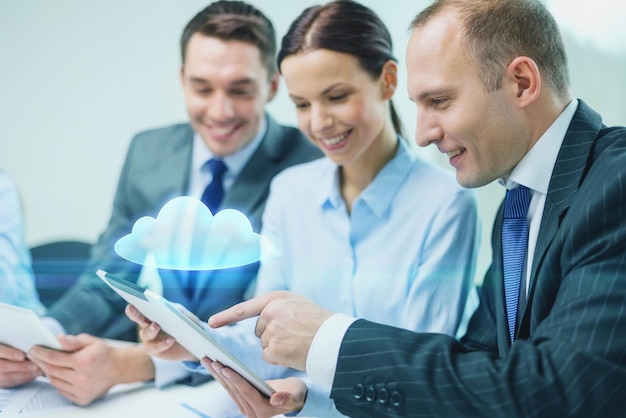 бизнес, технологии, облачные вычисления и концепция людей - улыбающаяся бизнес-команда с планшетным компьютером и виртуальной облачной проекцией, обсуждающая в офисе