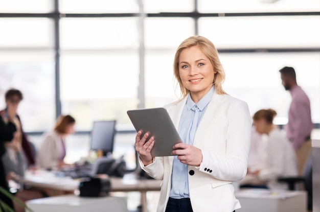 business, technology, corporate and people concept - smiling businesswoman with tablet pc computer at office