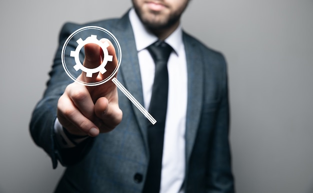 Business, technology and internet concept. businessman presses button with mechanism icon