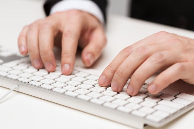 business, technology, internet and office concept - close up of businessman hands working with keyboard