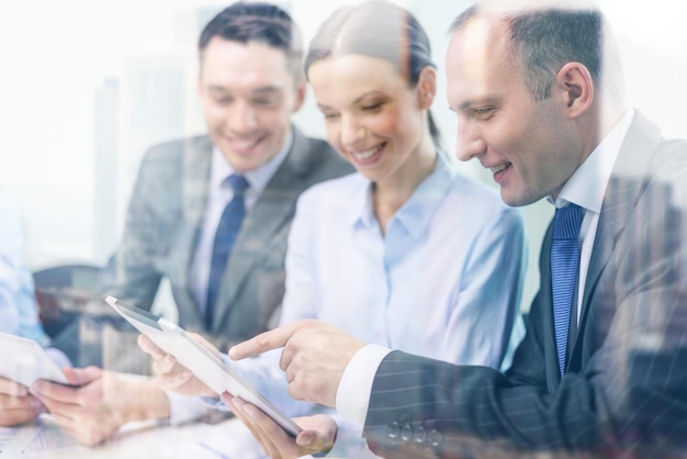 business, technology and office concept - smiling business team with tablet pc computer, documents and coffee having discussion in office