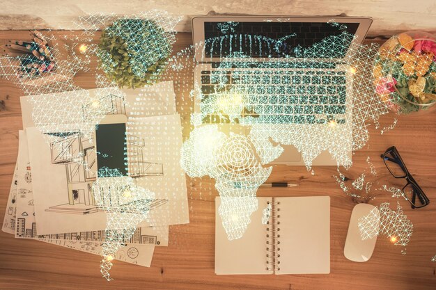 デスクトップの背景上のコンピューター上のビジネス テーマのホログラム描画上面図多重露光国際接続の概念