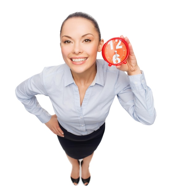 business, time and deadline concept - smiling businesswoman with red clock