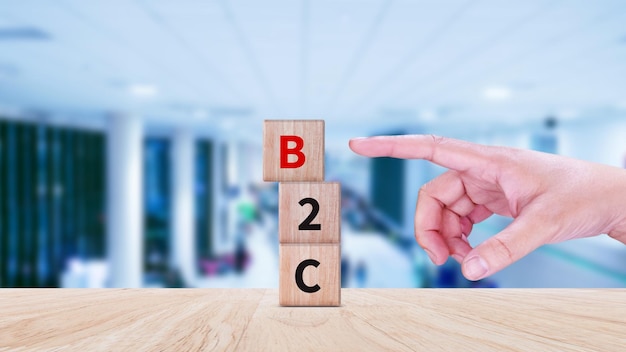 Foto business to customer b2c btc marketing concept hand aanraken houten kubussen met afkorting b2c icoon business financieel en marketing model management en service concepten