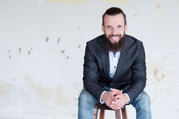 Business trainer or consultant smiling confident man in suit jacket sitting on a chair