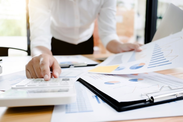 Business vrouw analyse investering voert gegevens document en het berekenen van een waarderingsnummer