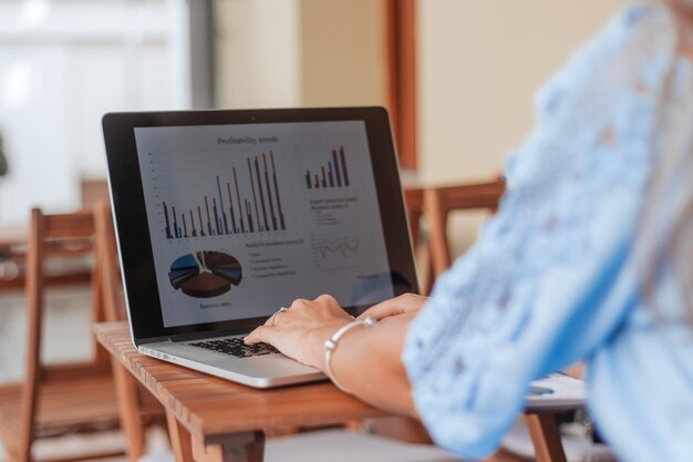 Business woman analyzing financial data sitting at a table in a cafe