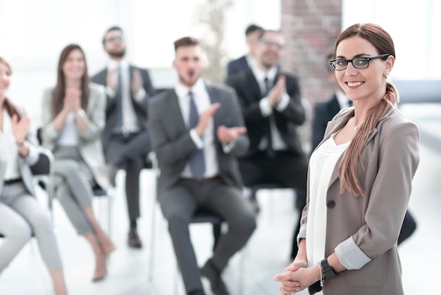 Business woman on blurred background of listeners in conference room