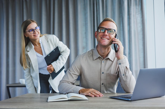 A business woman and a business man are discussing work in the office Modern office Colleagues in the office