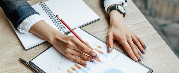 Business woman checks charts and refreshes financial progress. The girl analyzes the business model in the workplace.