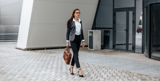 Una donna d'affari controlla l'ora in città durante una giornata lavorativa in attesa di una riunione. disciplina e tempistica. un dipendente va verso una riunione aziendale.