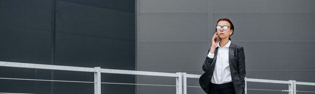 A business woman checks the time in the city during a working day waiting for a meeting. Discipline and timing. An employee goes towards a corporate meeting.