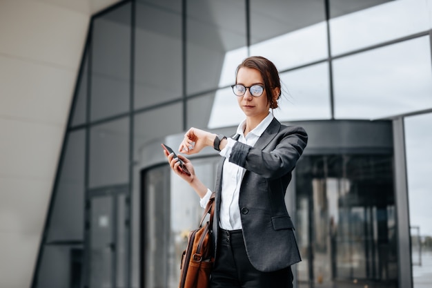 A business woman checks the time in the city during a working day waiting for a meeting