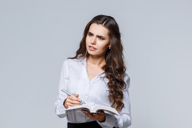 Business woman in classic suit makes notes.