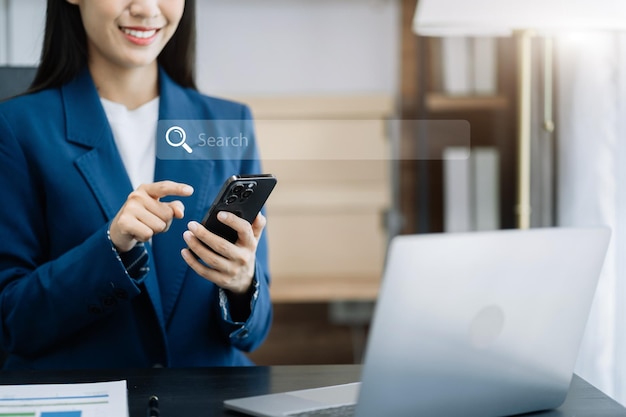 Business woman clicking internet search page on computer and smart phone touch screen in the office