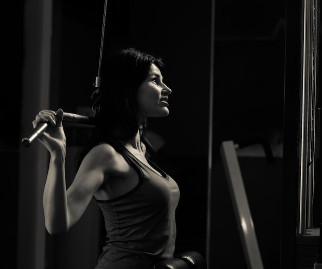 Business woman doing exercise on a fitness machine in a fitness club