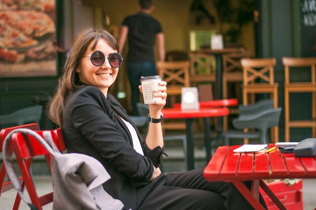 Donna d'affari che beve caffè in un caffè