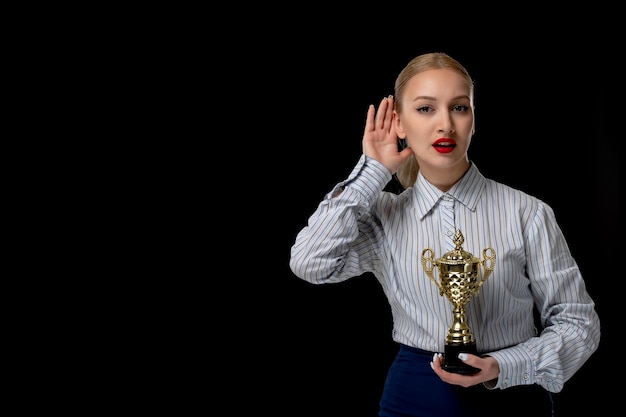 Business woman eavesdropping cute girl holding trophy with red lipstick in office outfit