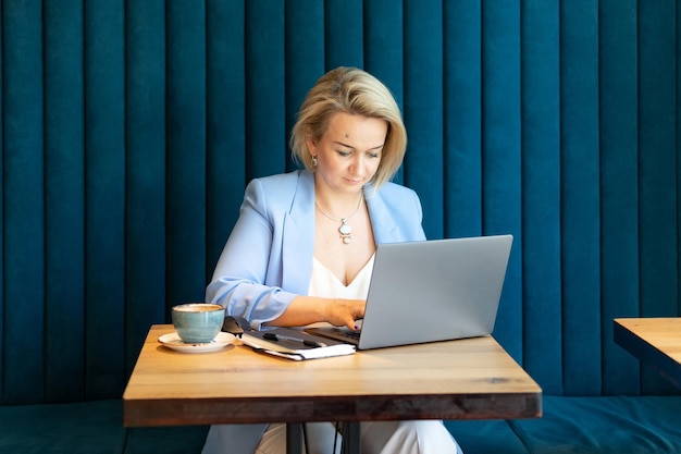 Donna d'affari faccia bella donna caucasica giovane o matura carriera professionale capo in tailleur lavorando su laptop donne moderne imprenditrici che lavorano in ristorante e bar piccola impresa