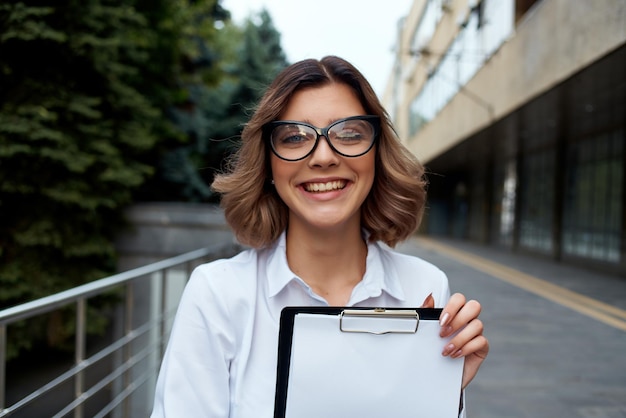 Business woman in glasses documents work on the street communication