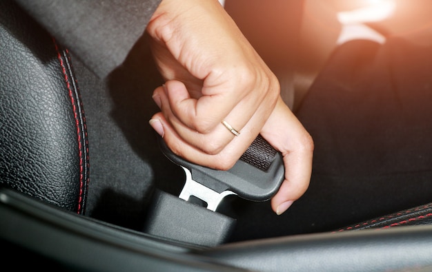 Photo business woman hand fastening a seat belt.