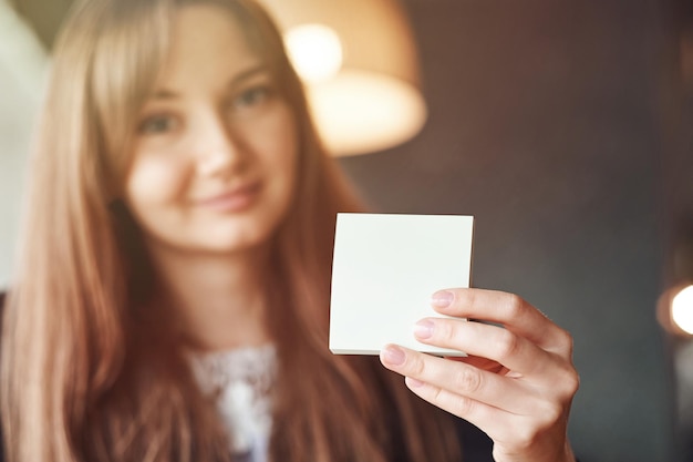 Photo business woman hand holding square blank clean sticker mock up close up background place for text