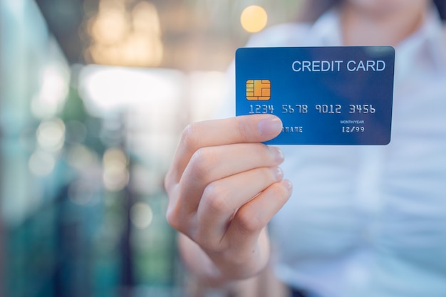 Business woman hand holds a blue credit card.