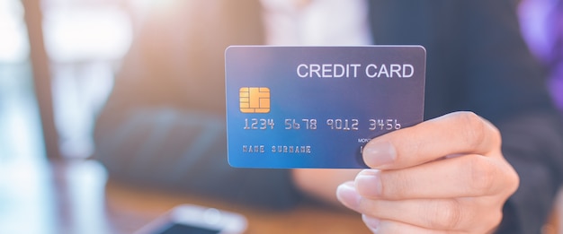 Business woman hand holds a blue credit card.