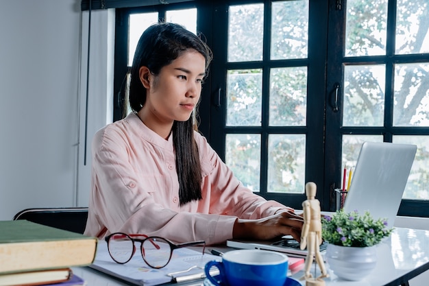 Photo business woman hands typing on keyboard and working on laptop computer in office.