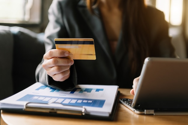 Деловая женщина вручает с помощью смартфона и держит кредитную карту с диаграммой эффекта цифрового слоя как концепцию онлайн-покупок
