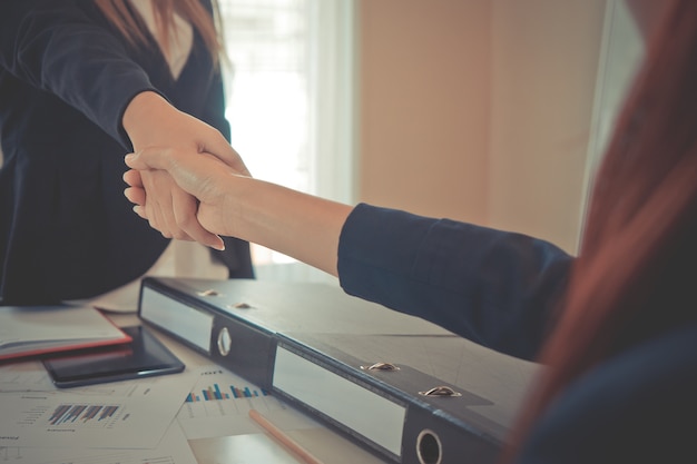 Business woman handshaking each other over a deal