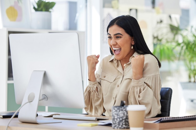 Business woman happy and excited at her office computer celebration of great news in email Financial freedom a deal and corporate success for startup employee after first sale on company website