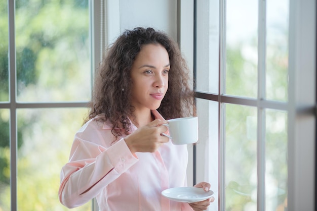 コーヒーと職場での喜びのために数分を持っているビジネスウーマン。