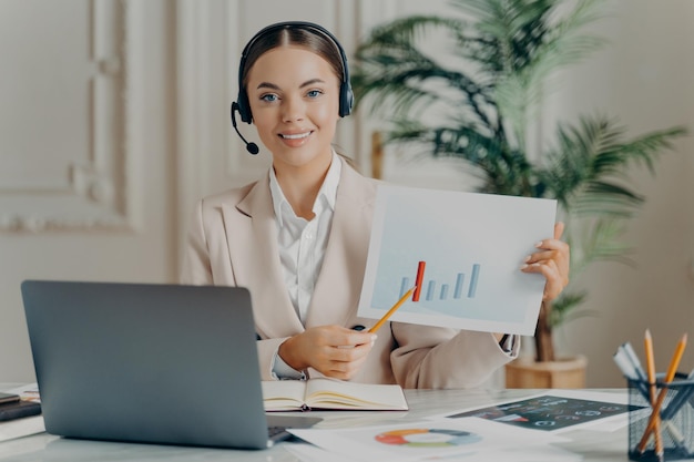 Business woman in headset with financial document or business plan