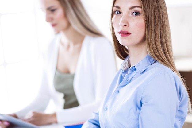 Business woman headshot. Businesspeople or colleagues discussing something at meeting while sitting at the desk in office. Casual clothes style. Audit, tax or lawyer concept.